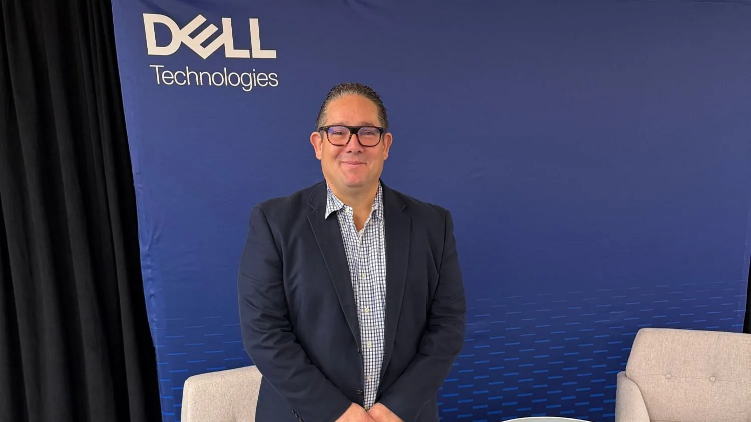 Ariel Coro standing in front of a Dell Technologies backdrop on a stage set